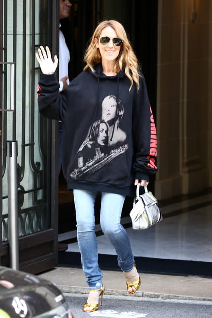 Céline Dion en sweatshirt noir à capuche Vetements et sandales dorées