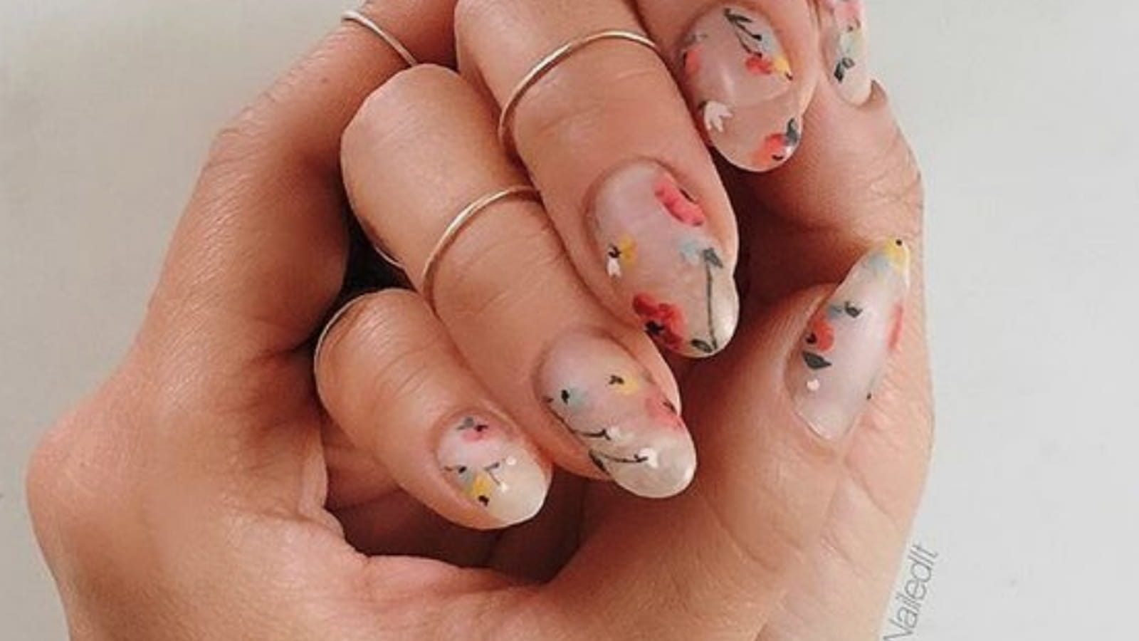 Une manucure avec des fleurs multicolores