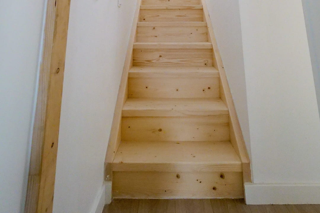 Un escalier en pin jusqu'au dernier étage
