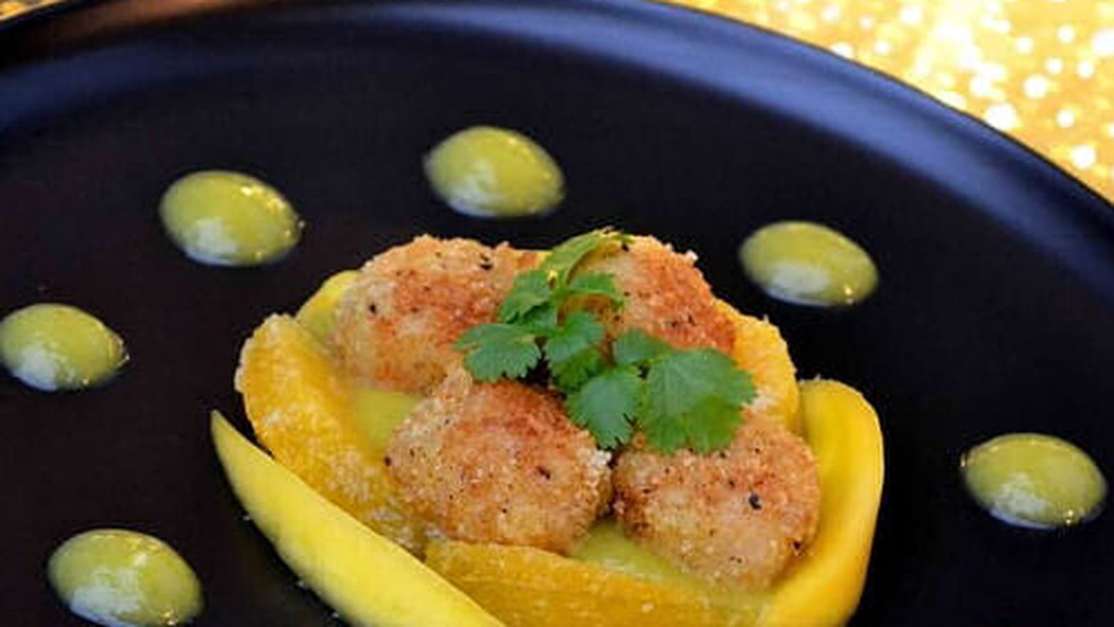 Noix de Saint-Jacques panées au curry, coulis de mangue et orange au coriandre