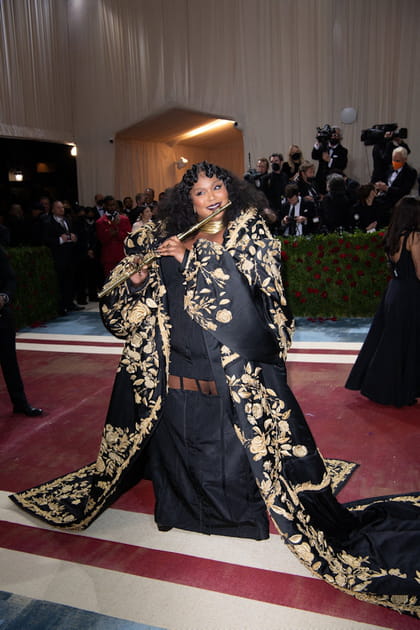 Lizzo dans un long manteau noir &agrave; broderies dor&eacute;es