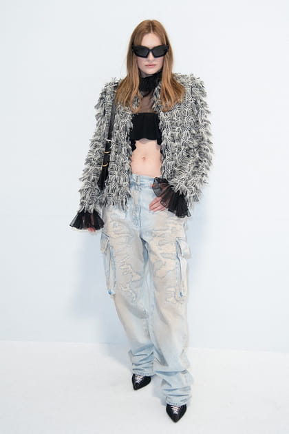 Camille Razat en veste bi-matière et jean clair délavé au défilé Givenchy