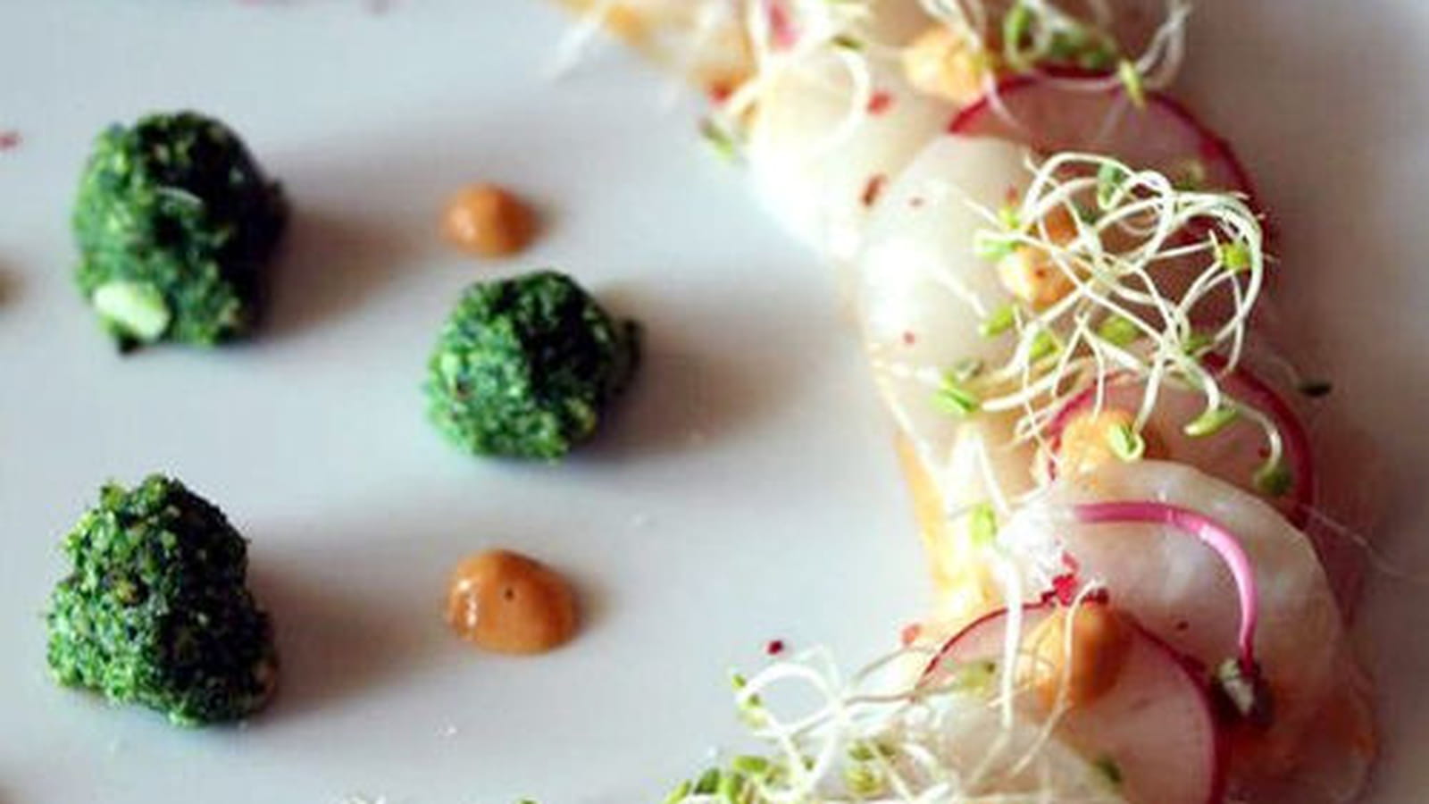 Noix de Saint-Jacques en carpaccio, corail crémé, radis et son pesto de fanes