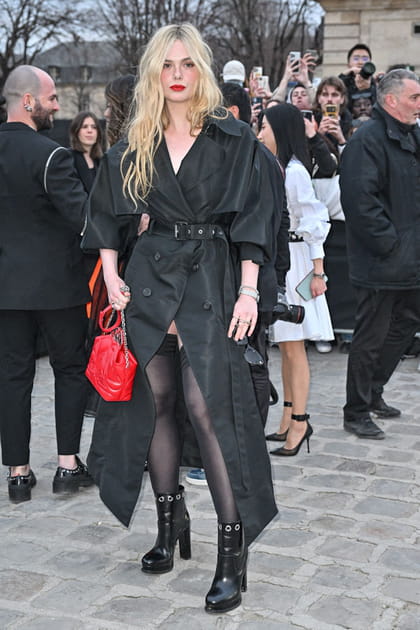 Elle Fanning en trench noir ceintur&eacute; et sac &agrave; main carr&eacute; rouge au d&eacute;fil&eacute; Alexander McQueen