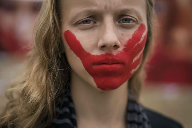 Une main rouge sur la bouche contre les violences faites aux femmes