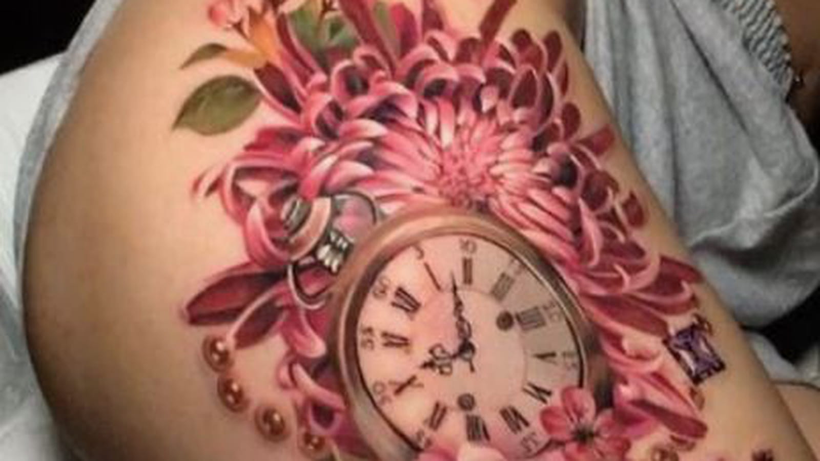 Horloge et fleurs roses sur la cuisse
