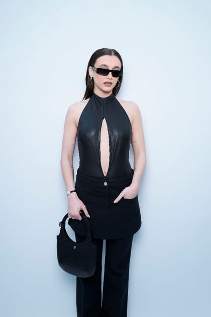 Emma Chamberlain en top en latex ajour&eacute;, jupe et pantalon noir