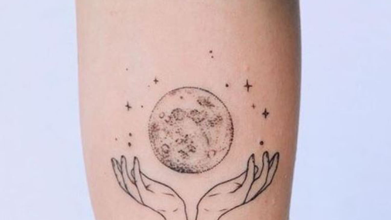 Lune et mains délicates sur le bras