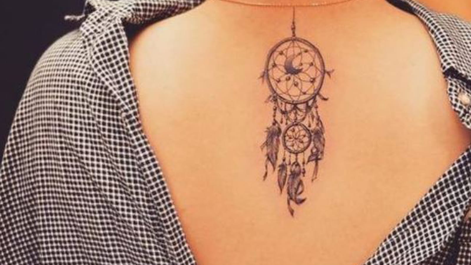 Tatouage plume et attrape-rêve dans le dos