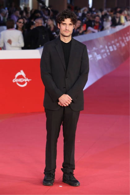 Louis Garrel en costume noir et pull fin