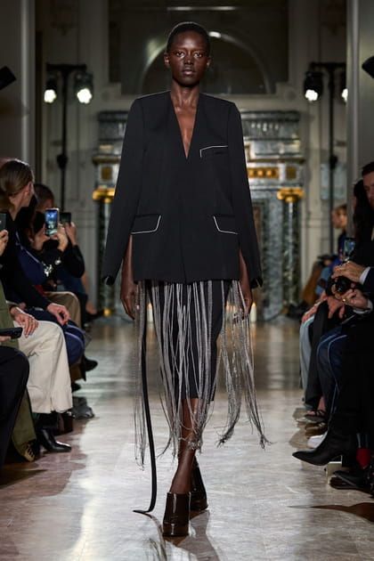 Veste à franges et jupe crayon noire aperçues sur le défilé Victoria Beckham