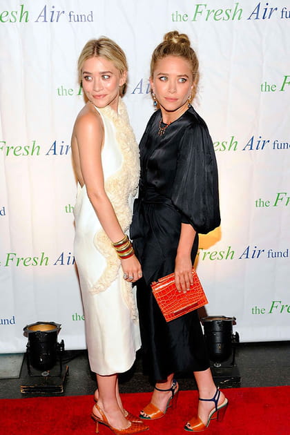 Ashley Olsen en robe dos nue crème, Mary-Kate Olsen en robe noire fluide à manches bouffantes