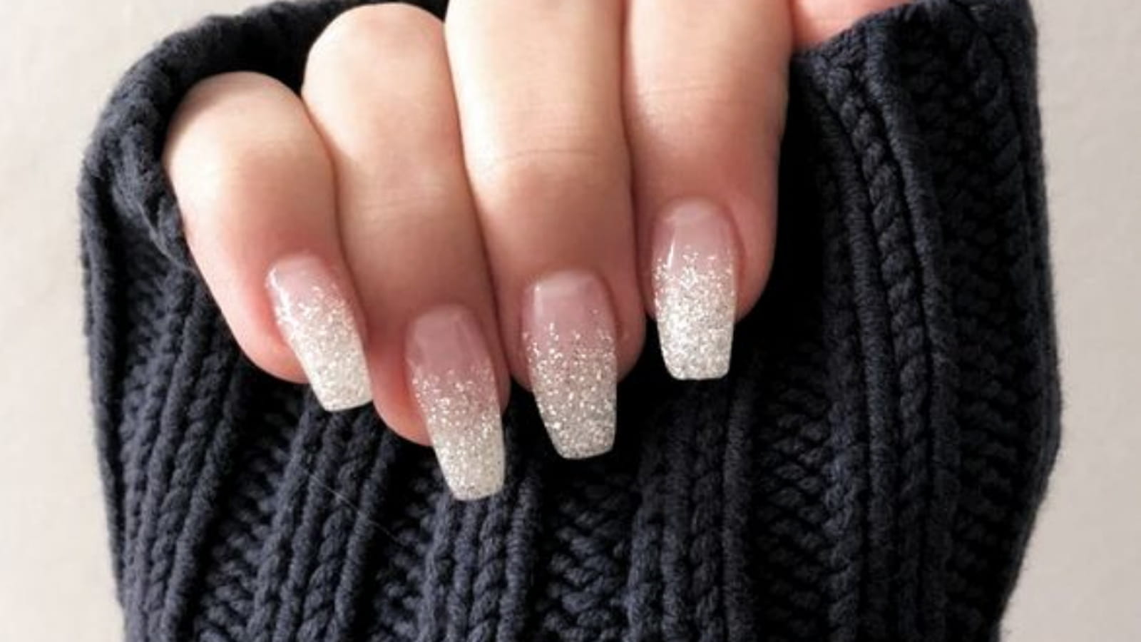 Une manucure avec un dégradé de paillettes blanches