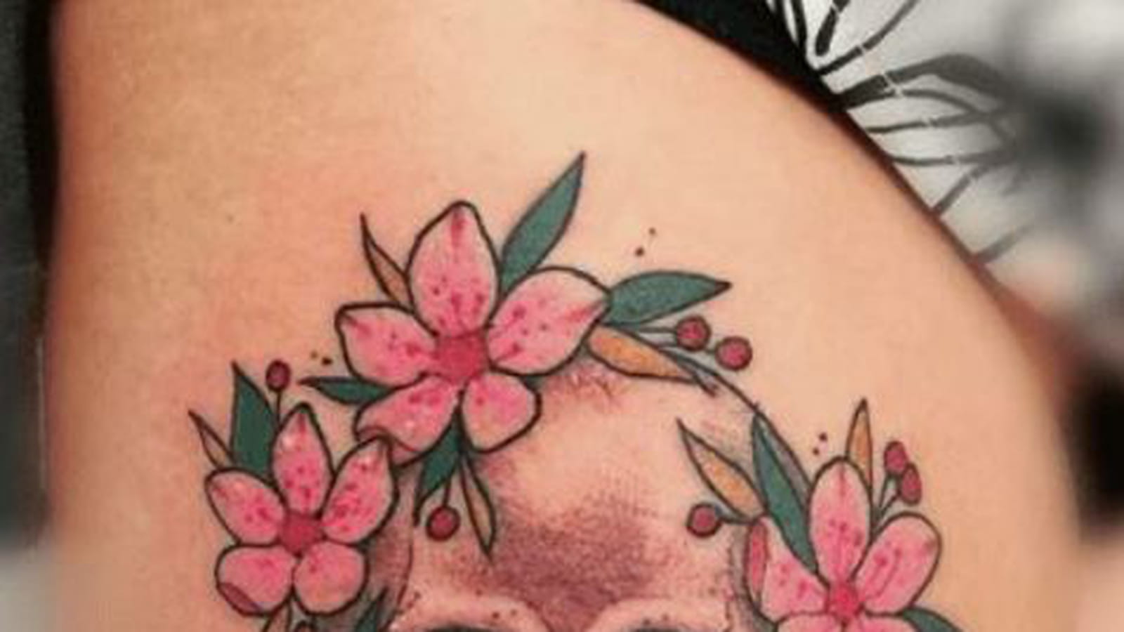Fleurs de cerisier et tête de mort sur la cuisse