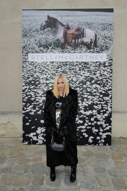 Avril Lavigne en manteau long texturé et bottes noires à bouts carrés au défilé Stella McCartney