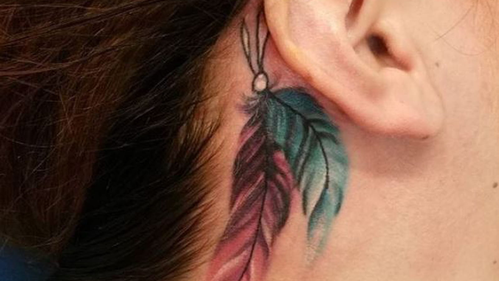 Tatouage plume derrière l'oreille