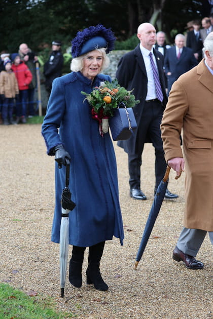 Camilla Parker-Bowles en manteau long fluide bleu marine et petite mallette assortie