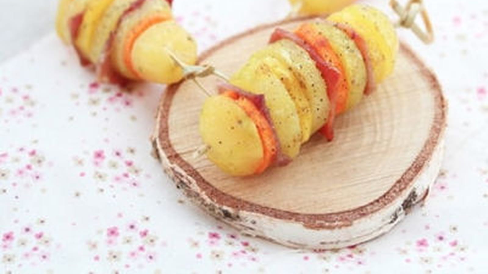 Brochettes de pommes de terre, carottes oranges et jaunes, jambon cru