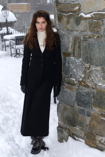 Laetitia Casta en manteau long noir et pull blanc à col roulé