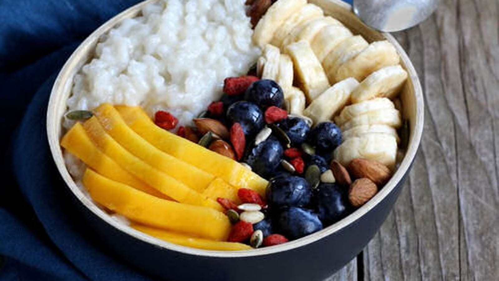 Porridge de riz au lait de coco, bananes, myrtilles et mangue