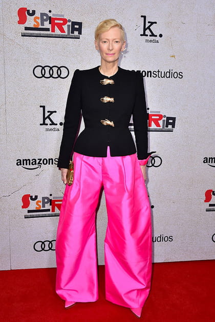 Tilda Swinton en veste noire et pantalon fuchsia