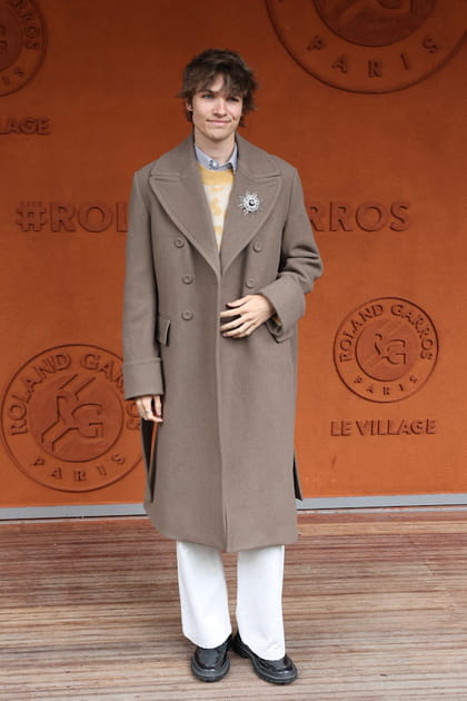 Pierre de Maere en manteau taupe et pantalon blanc