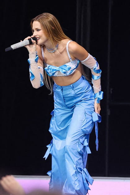 Angèle en pantalon bleu à nœuds et brassière