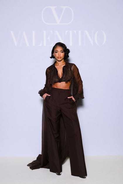 Lori Harvey en crop top marron à manches longues transparentes et pantalon taille haute au défilé Valentino