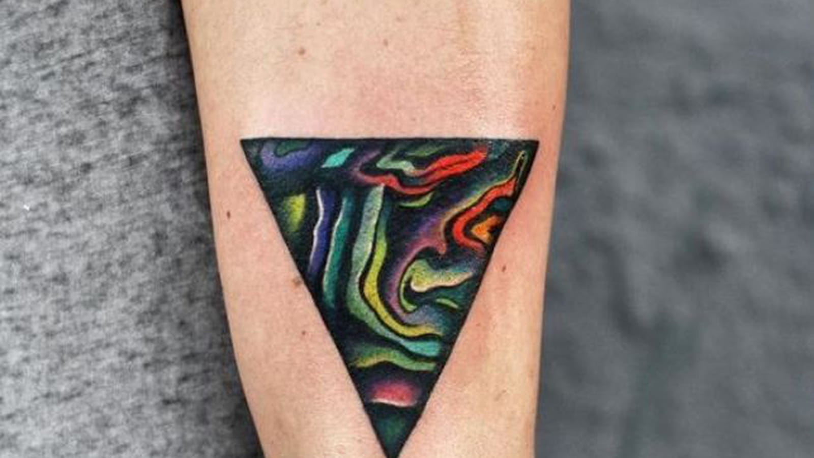 Triangle coloré sur le bras