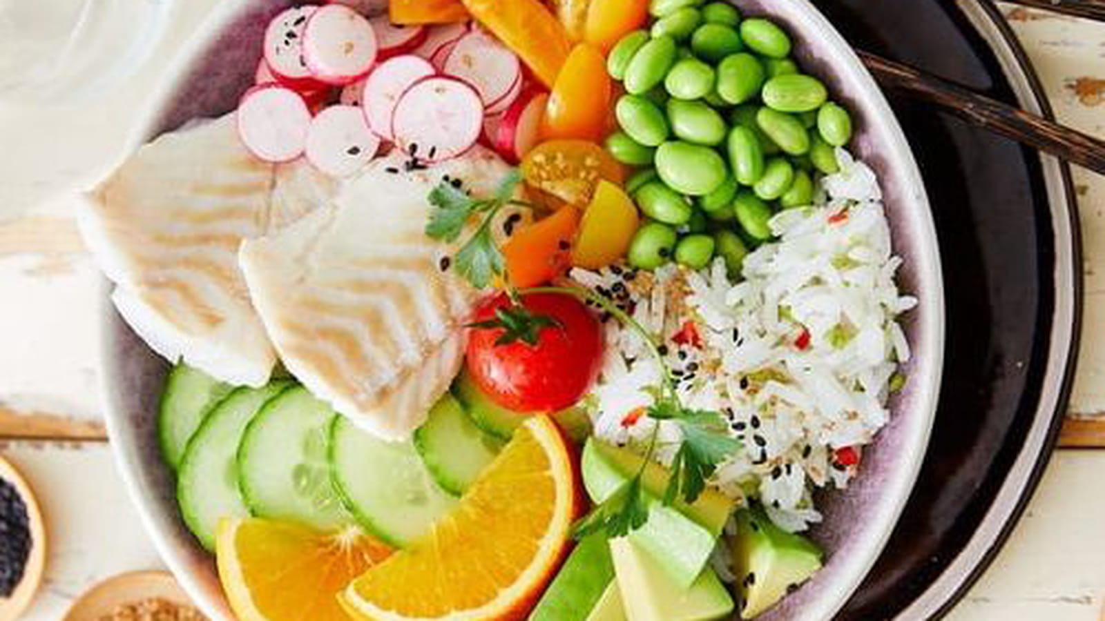 Bowl de cabillaud, tomates cerises, radis, avocats, fèves, riz et concombre