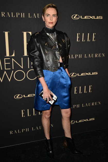 Charlize Theron en veste en cuir et jupe bleue satinée