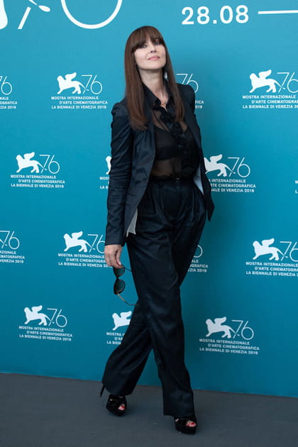Monica Bellucci en chemisier en tulle transparente et pantalon de costume