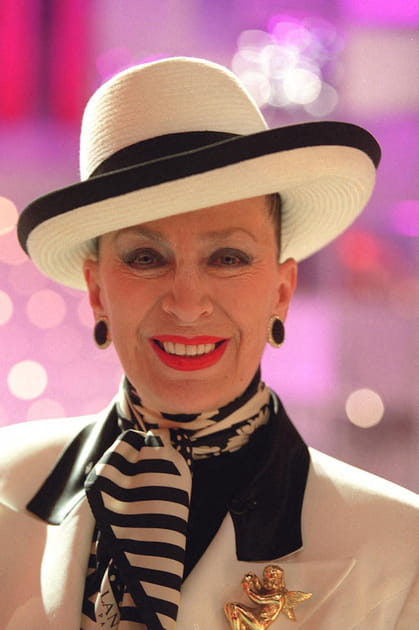 Geneviève de Fontenay en chapeau blanc, foulard bicolore et broche dorée