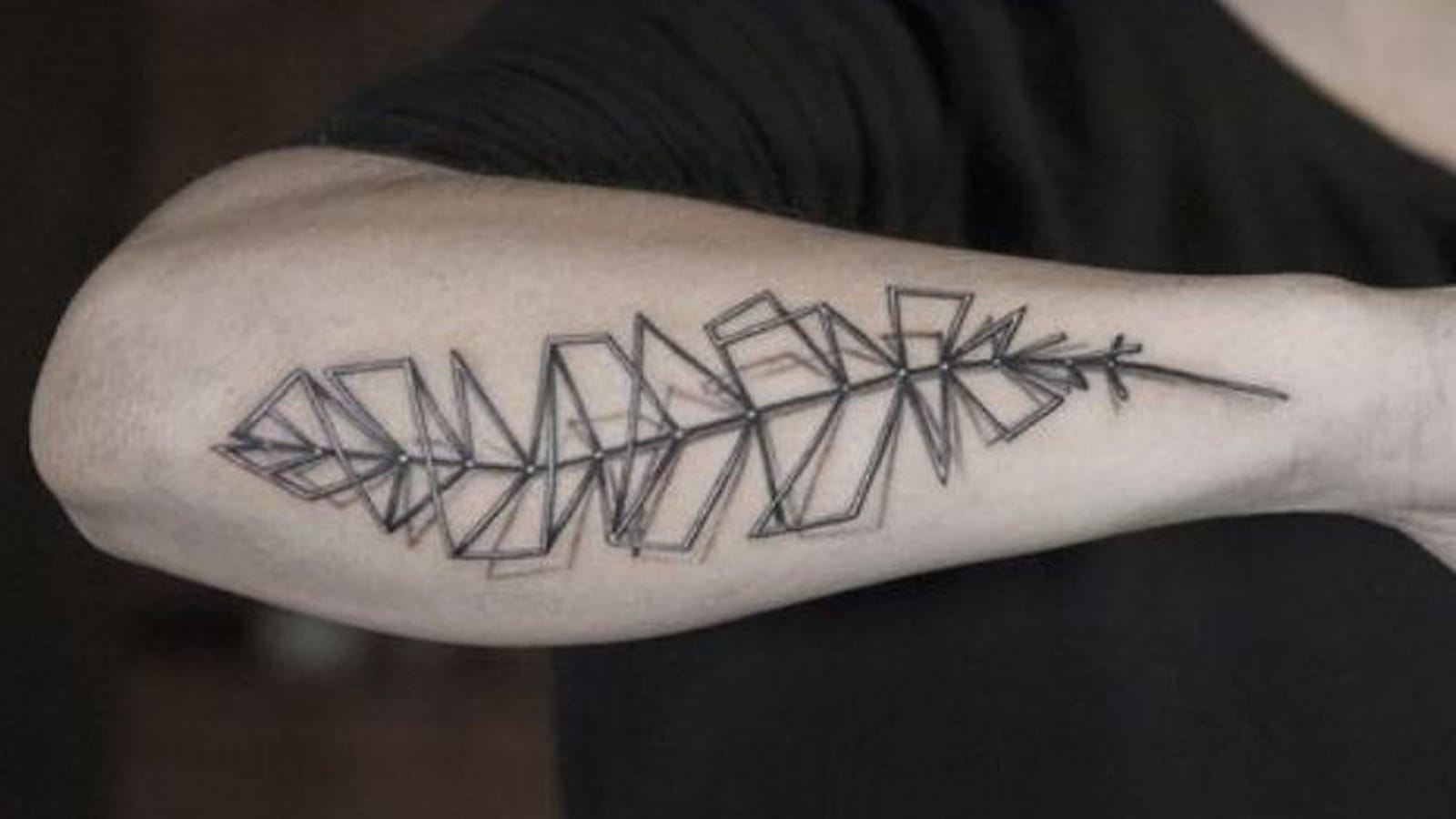 Tatouage plume origami sur l'avant-bras