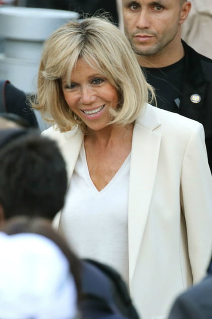 Brigitte Macron en total look blanc avec un chemisier décolleté en V et blazer