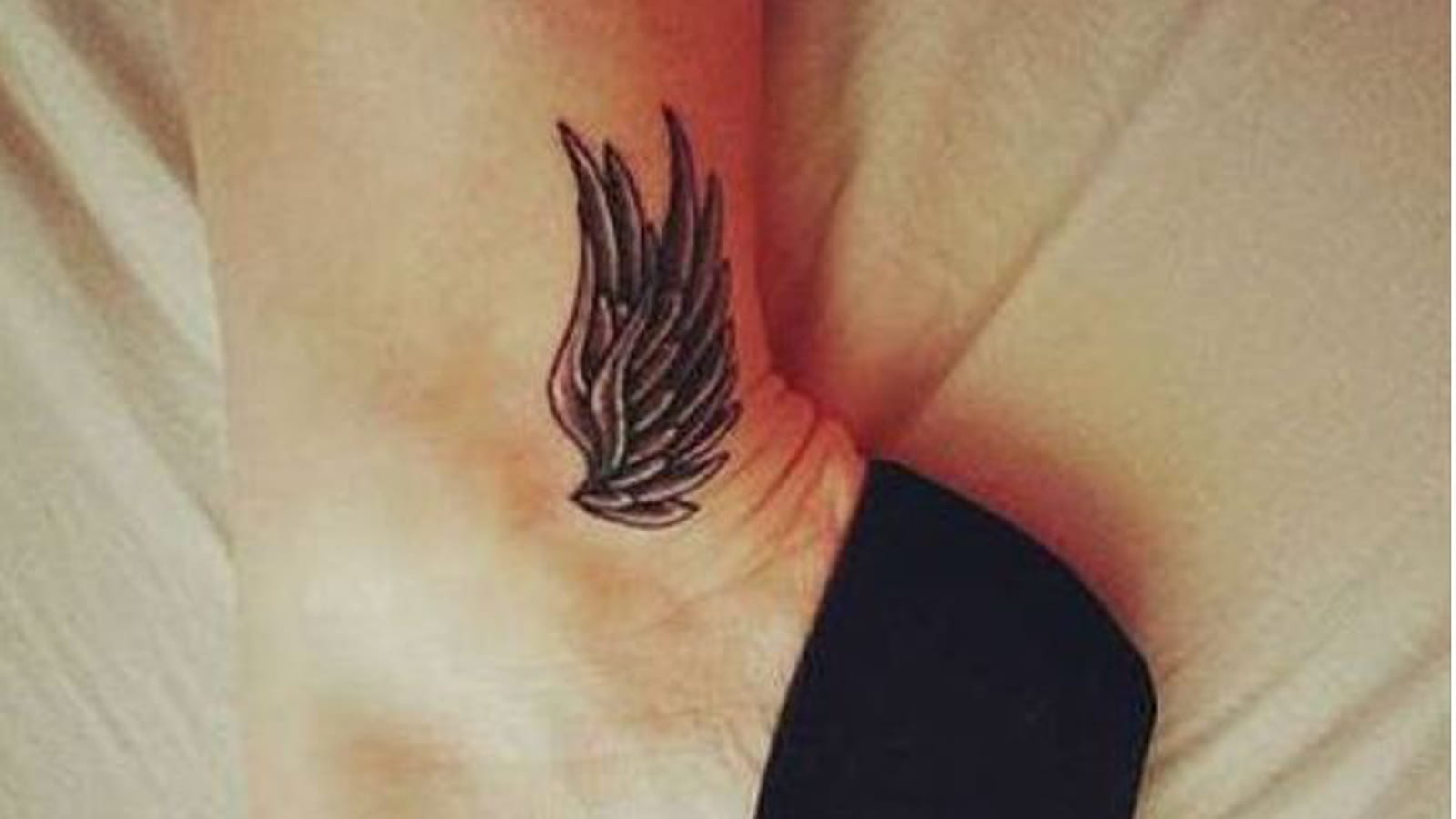 Tatouage plume sur la cheville